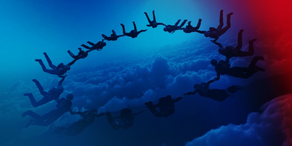 Fallschirmspringer die eine kreisförmige Formation bilden und sich an den Händen halten.
