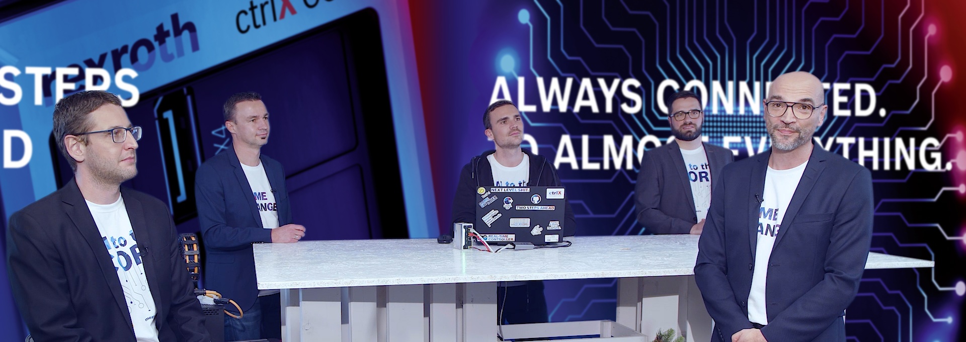 Gastgeber Christian Zentraf und seine Gäste Johannes Albrecht, Pedro Reboredo, Holger Schnabel und Kai Müller sitzen an einem Tisch und sprechen über die grafische Programmierung mit Blockly der Automatisierungslösung ctrlX AUTOMATION