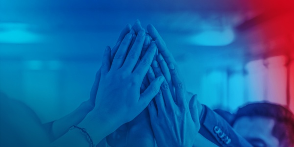 Hände von vielen Menschen, die zusammen einen High-Five machen.