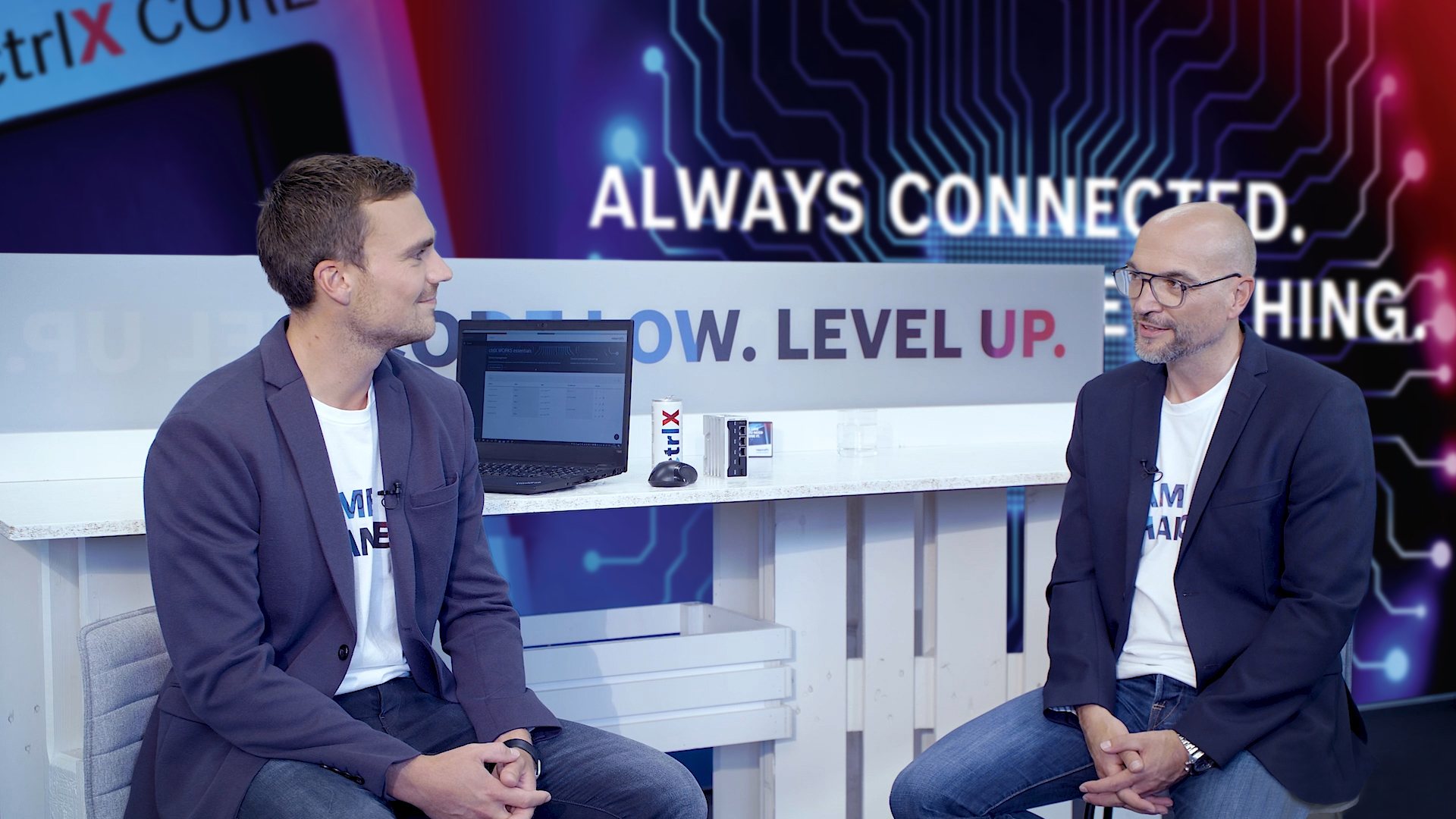 Gastgeber Christian Zentraf und sein Gast Johannes Albrecht sitzen an einem Tisch und sprechen über den ctrlX Data Layer, dem zentralen Nevensystem der Automatisierungslösung ctrlX AUTOMATION
