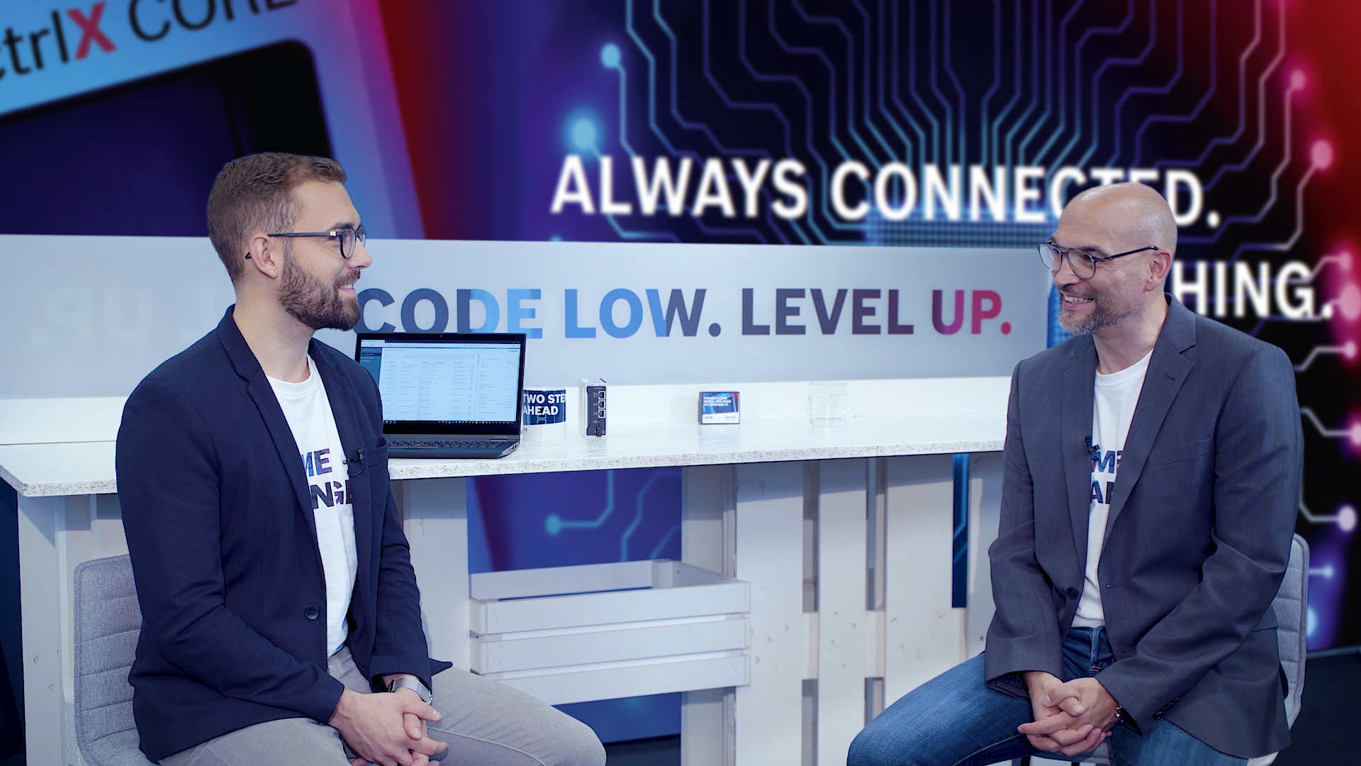 Gastgeber Christian Zentraf und sein Gast Julian Weinkoetz sitzen an einem Tisch und sprechen über das ctrlX Device Portal, dem zentralen Gerätemanager der Automatisierungslösung ctrlX AUTOMATION