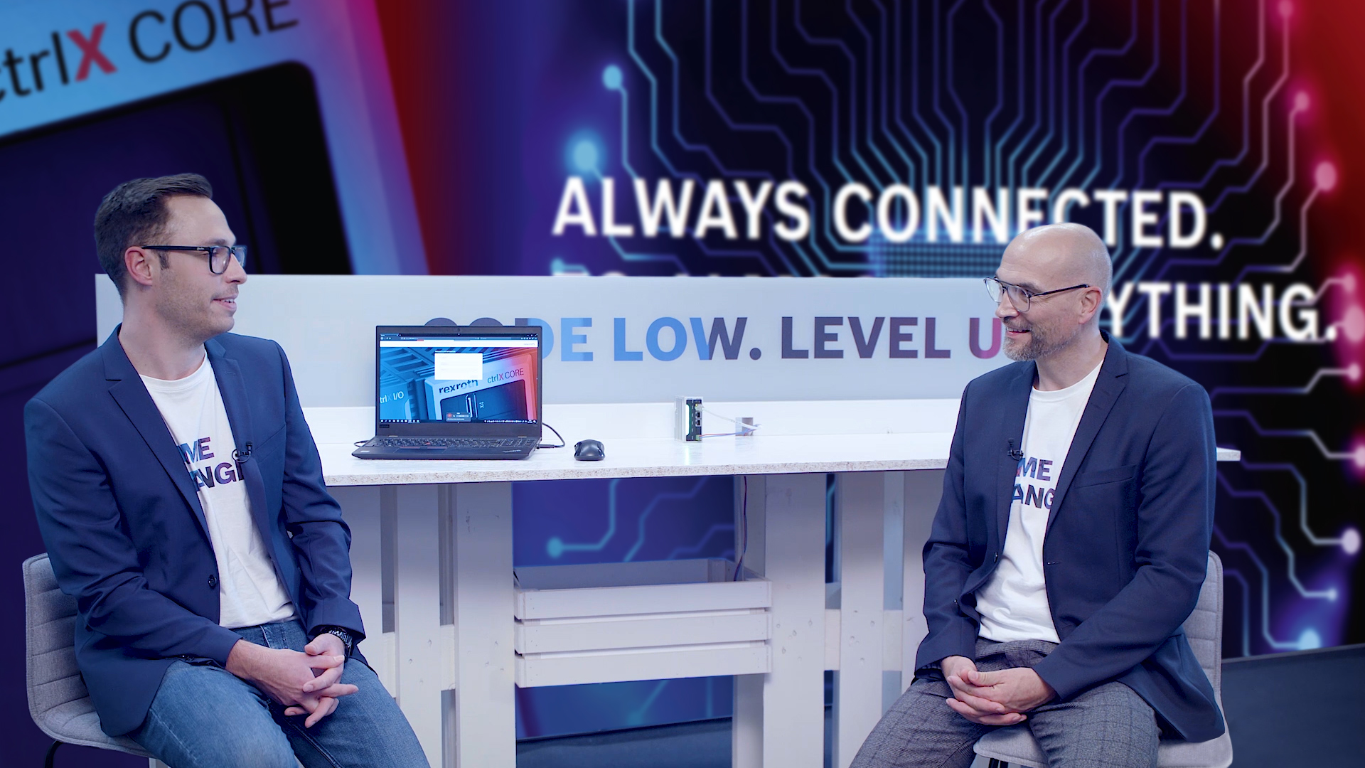 Gastgeber Christian Zentraf und sein Gast Alexander Breitenbach sitzen an einem Tisch und sprechen über das ganzheitliche Sicherheitskonzept der Automatisierungslösung ctrlX AUTOMATION