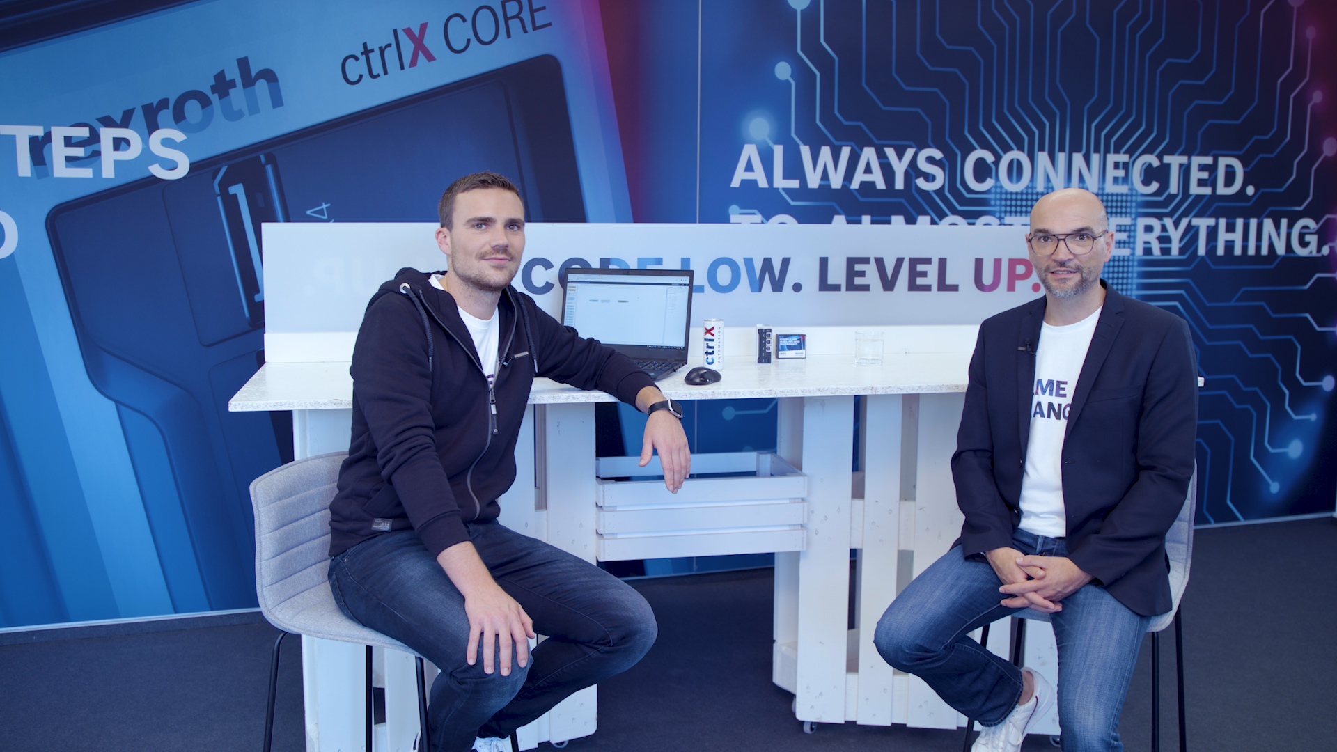 Gastgeber Christian Zentraf und sein Gast Johannes Albrecht sitzen an einem Tisch und sprechen über standartisierte Schnittstellen, wie das REST-Interface, der Automatisierungslösung ctrlX AUTOMATION